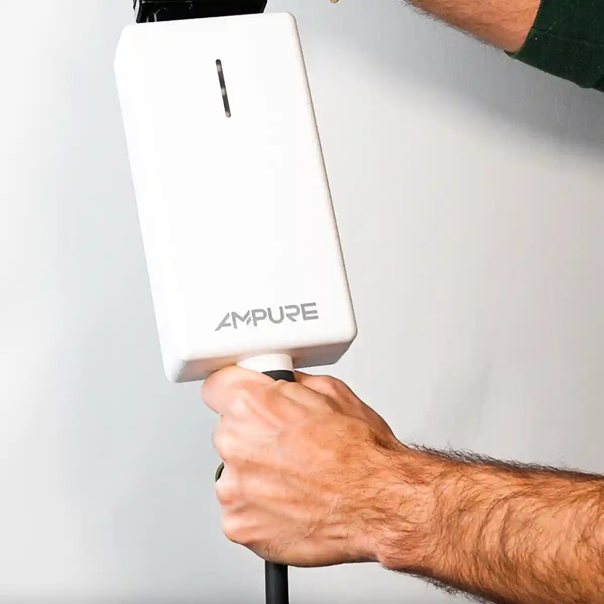 Hand holding a white device with 'AMPURE' branding against a light gray background