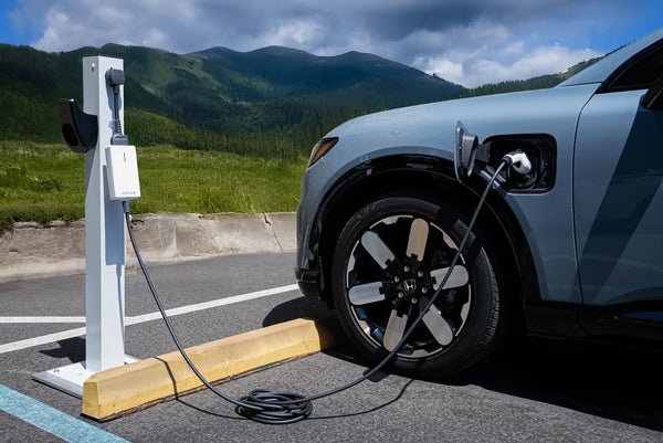 Electric vehicle charging at a charging station with mountains in the background