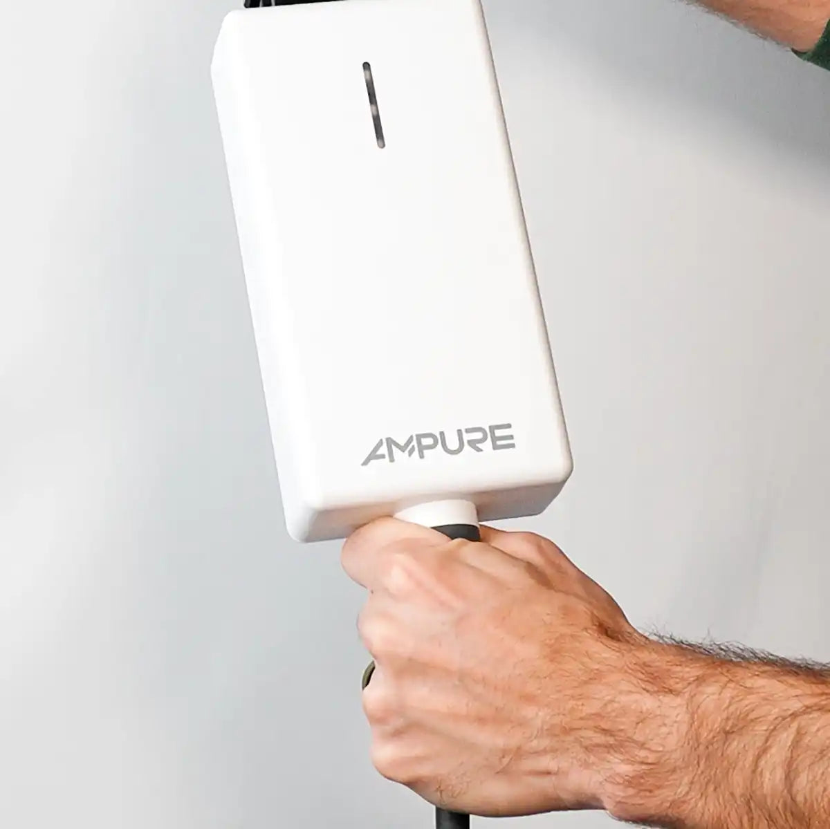 Hand holding a white device labeled 'AMPURE' against a gray background